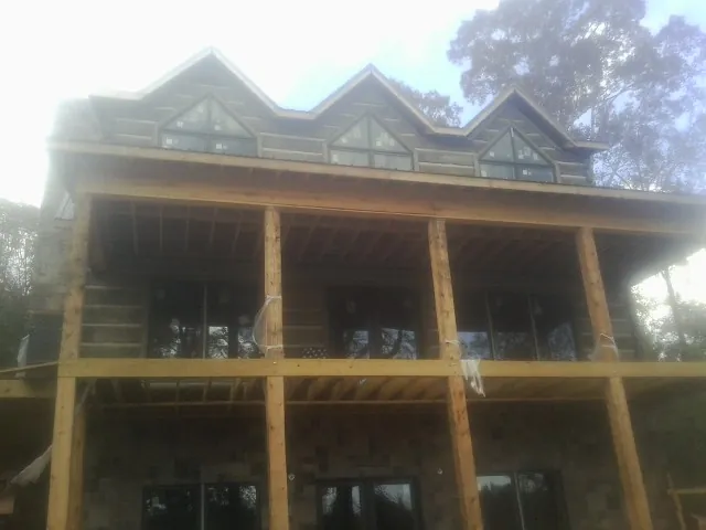 Dormers and porch framing on a large log home under construction — Roof Coating work by our crew in South Jordan
