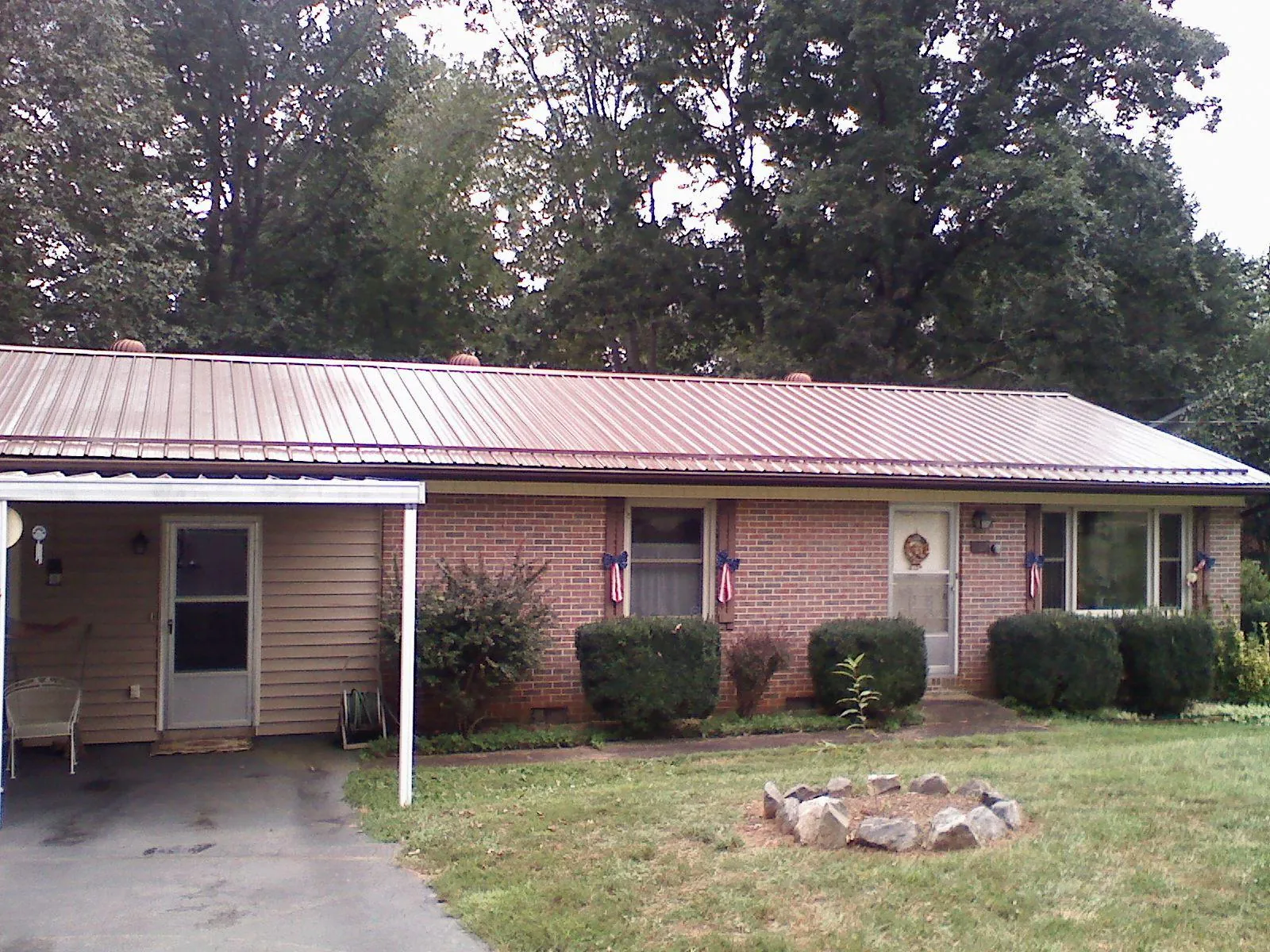 Bronze metal roof and carport on a brick ranch home — Roof Repair work by our crew in South Jordan