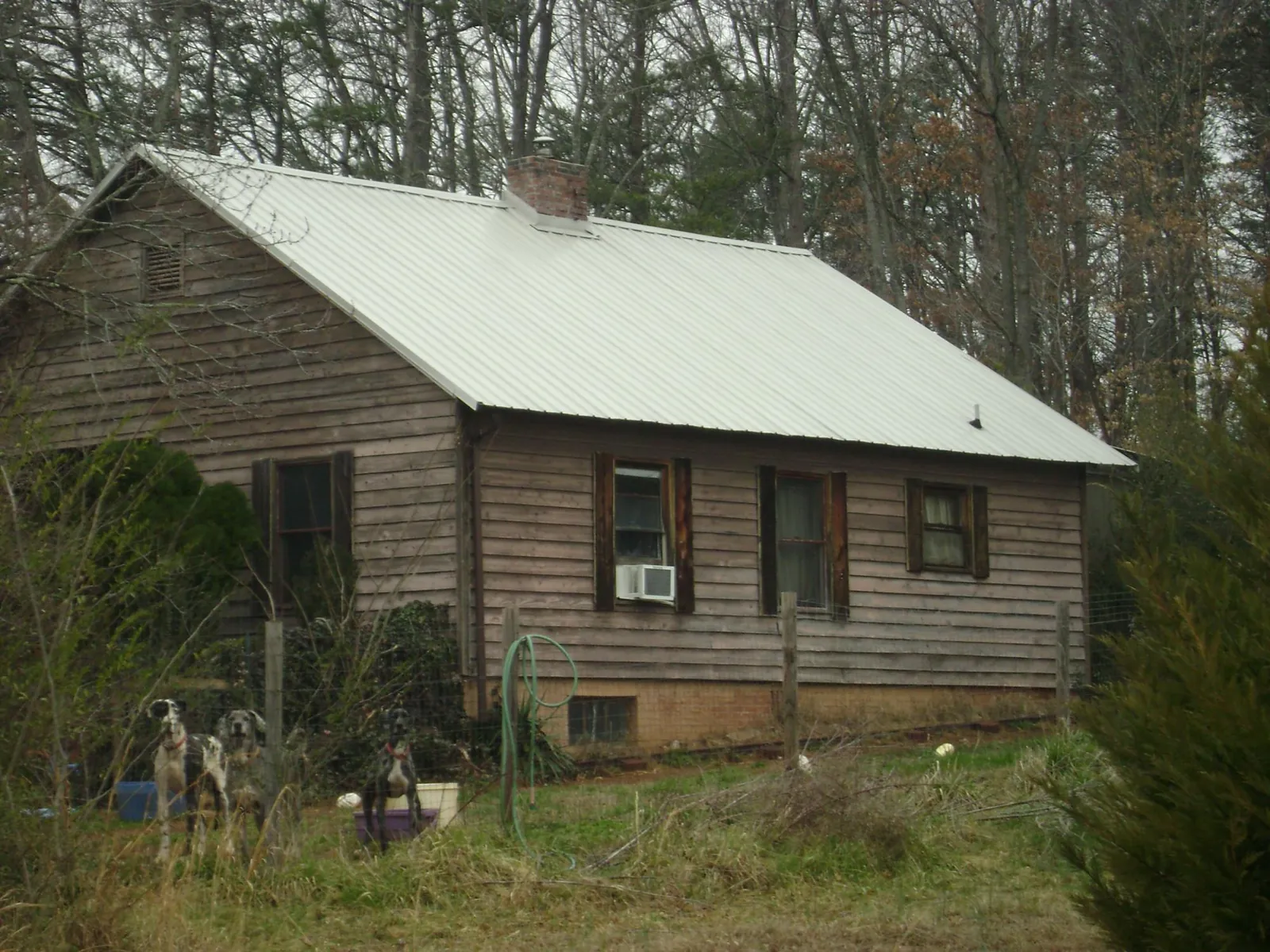 White metal roof on an old wood sided farmhouse, from a Asphalt Shingle Roof Repair job in South Jordan